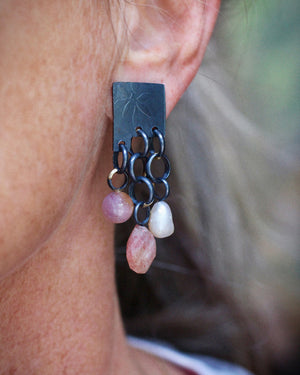 Close up of pastel colored gemstonand pearl tab earrings with handmade chain dangles in deep oxidized sterling silver with 14k gold accents. Shown worn on ear.