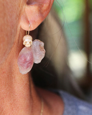 Close-up of one pearl skull and rose colored Gobi Desert agate earring hanging from a handmade 14k gold ear wire.