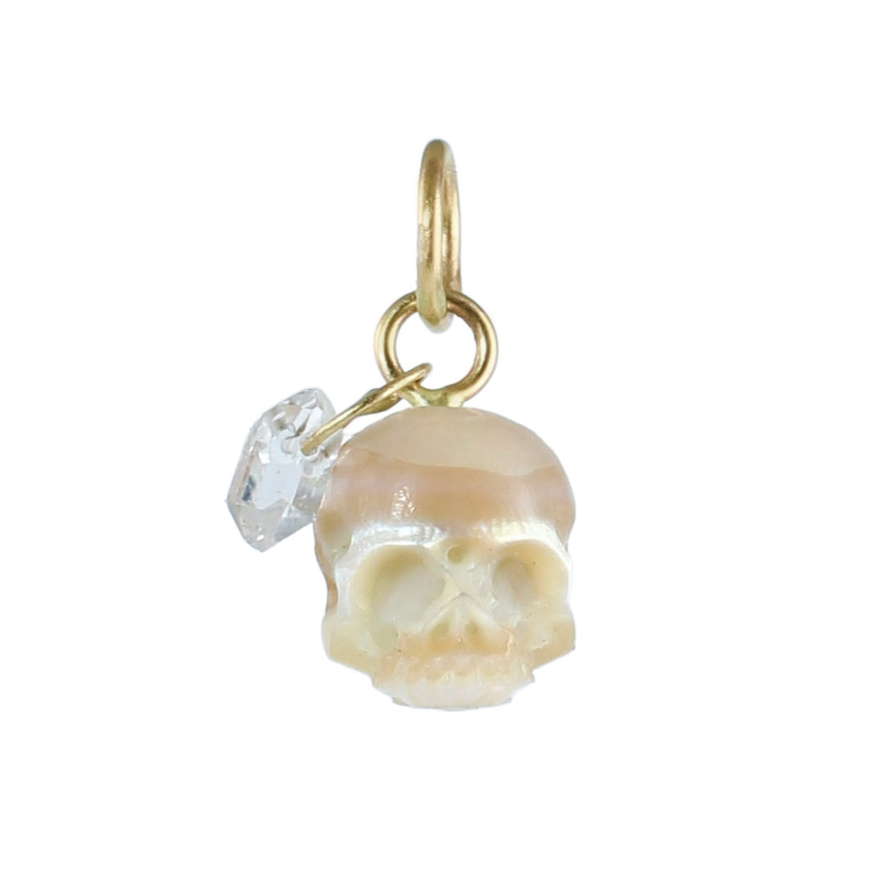Hand-carved cream pearl skull charm with a clear Herkimer diamond dangle and recycled 14k gold rings on a white background.