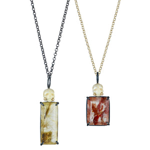 Two pearl Calavera pendants worn on chains, one with red rutile quartz on a gold chain and one with golden rutile quartz on an oxidized silver chain.