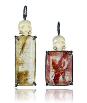 Side-by-side view of pearl Calavera pendants with faceted golden and red rutile quartz, oxidized sterling silver, and recycled 14k gold details.