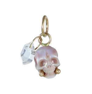 Carved lavender pearl skull charm with gold accents paired with a luminous Herkimer diamond crystal dangle shown on a white background.