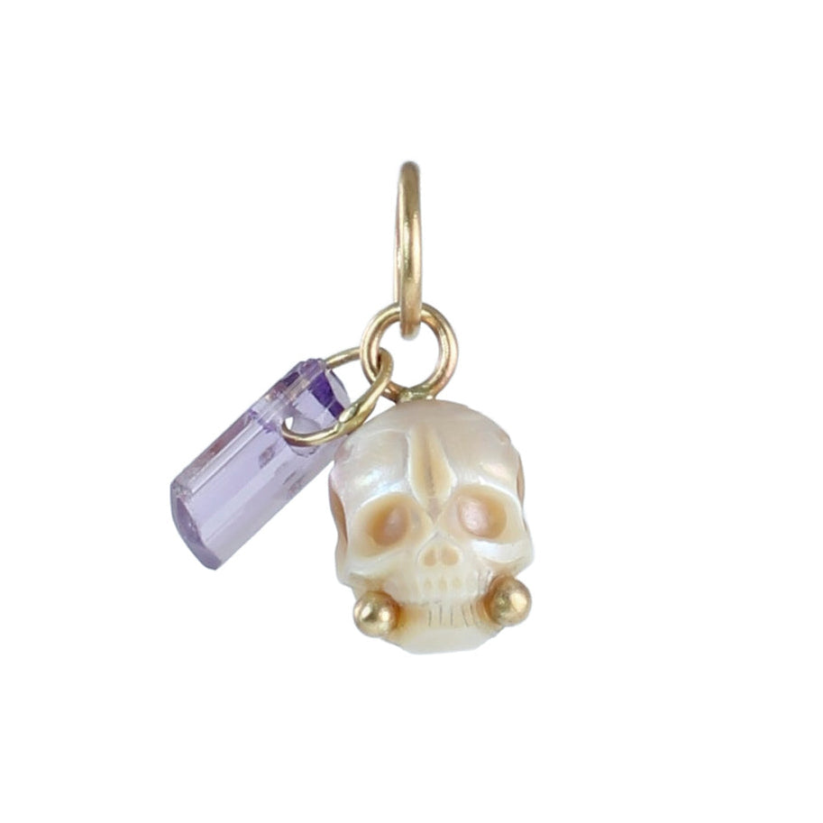 Hand-carved cream pearl skull charm with lavender crystal dangle and recycled 14k gold accents on a white background.