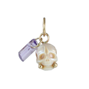 Hand-carved cream pearl skull charm with lavender crystal dangle and recycled 14k gold accents on a white background.