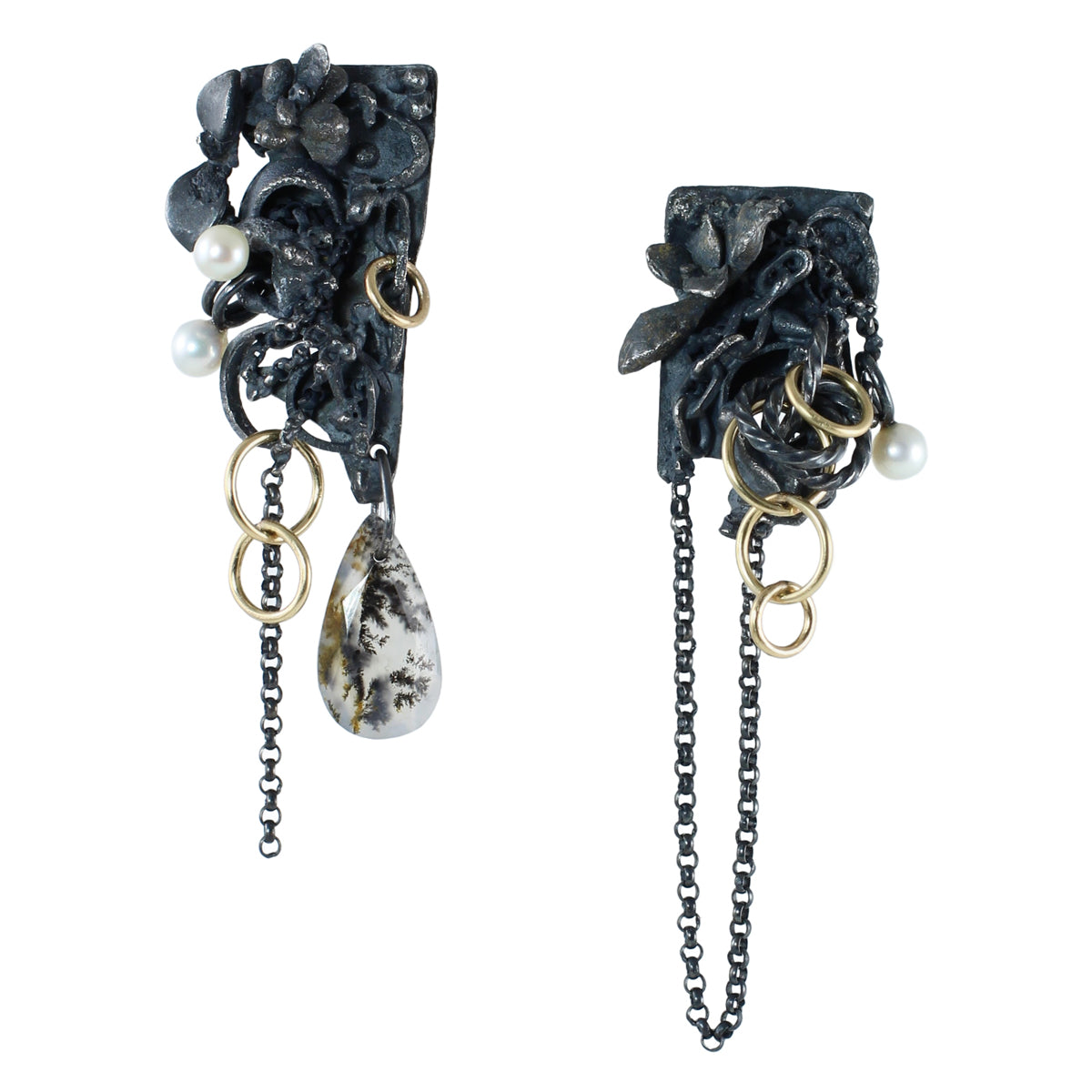 Asymmetrical Fragment earrings in textured oxidized sterling silver with 14k gold fill rings, white pearls, dangling chains, and a teardrop dendritic agate with branching black and brown inclusions photographed floating on a white background.