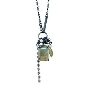 One-of-a-kind green sunstone necklace on a white background with pearls, oxidized sterling silver, collected fragments and a dangling length of crystal chain.