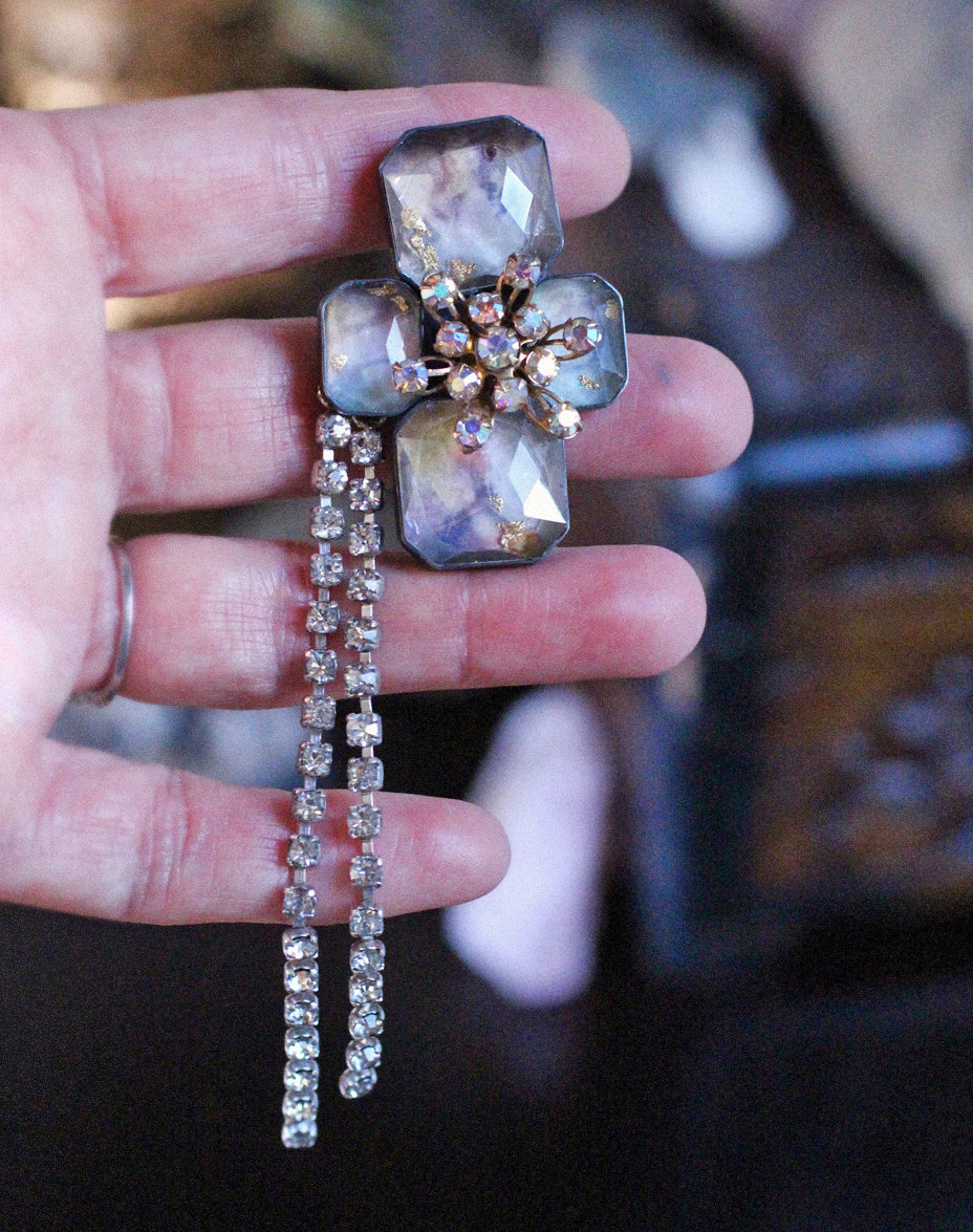 One-of-a-kind brooch with pastel-toned stones and vintage crystal center, worn with removable rhinestone chain dangles cascading downward