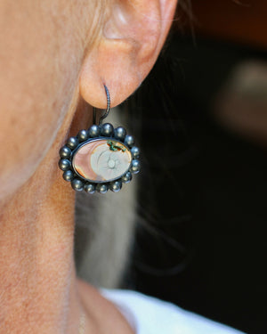 Imperial jasper and oxidized silver earrings worn on the ear, showing the soft pink, cream, and blue markings in the stones.