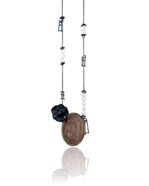 A 24-inch asymmetrical necklace with a large rosette-patterned imperial jasper, cast silver orchid, freshwater pearls, and oxidized sterling silver chain.