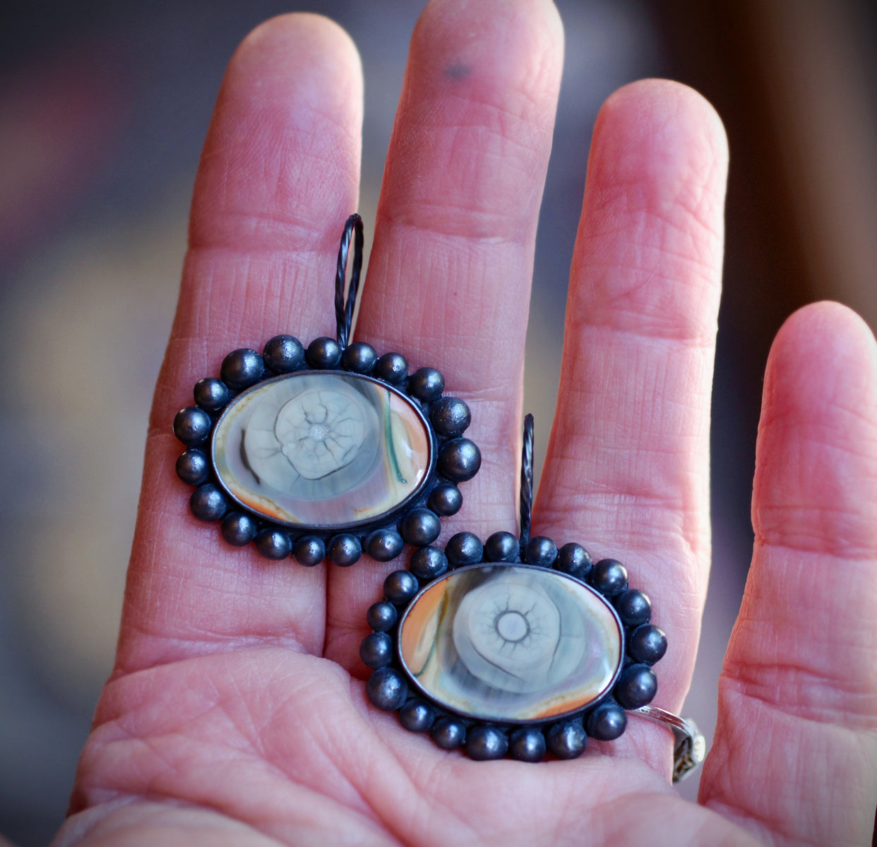 Pair of Imperial jasper eye earrings on a white background, each set in oxidized sterling silver with a rounded beaded border and twisted ear wire.