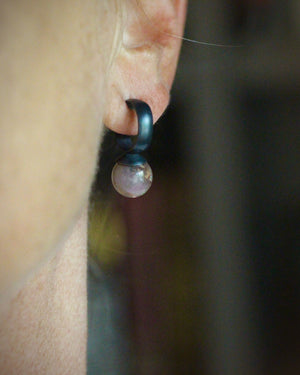 Mini rose quartz bauble hoop earring worn on the ear, showing the small oxidized silver hoop and smoky pink gemstone drop.