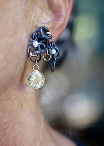 Close-up video of a Fragments earring worn on the ear, with fused oxidized sterling silver, pearls, gold accents, and a large round faceted citrine drop. Shows movement and scale. 