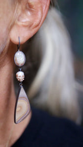 Video of one the long Calavera earrings worn on the ear with sparkling opalized druzy, carved pearl skull, and banded polychrome jasper drop. Shows movement and scale.