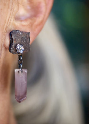Video showing movement and scale of an asymmetrical rust shard earring with a Herkimer diamond and dangling pale pink lithium quartz crystal while worn on ear.