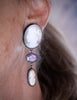Video of a cameo drop earring worn on ear featuring an antique shell cameo, hexagon pink sapphire, smaller cameo drop, and oxidized silver setting.