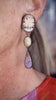 Video of handmade long earrings worn on ear, featuring vintage shell cameos, fossilized palm wood, and lilac phosphosiderite set in oxidized sterling silver showing movement.