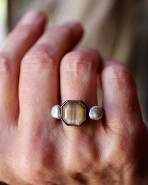Handmade golden sapphire and pearl ring worn on finger, oxidized sterling silver band with balanced modern design and natural gemstone detail