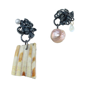 One-of-a-kind mismatched earrings with fused oxidized sterling silver and tiny skulls, paired with a found shell fragment, pink pearl, moonstone, and 14k gold photographed on a white background.