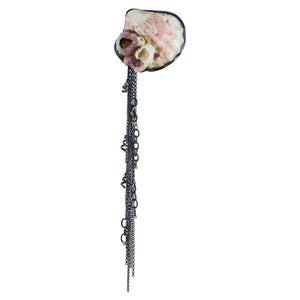 Found shell brooch from Maui with pink and cream tones, set in oxidized silver, featuring long cascading chain fringe with small gold accents on a white background.