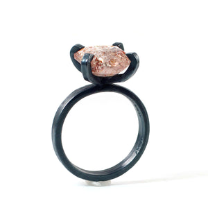 Side profile of a faceted sunstone ring showing its elevated four-prong setting and handmade oxidized sterling silver band.