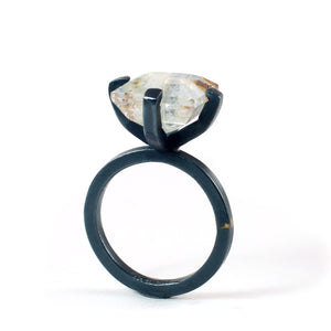 Full side profile of a white topaz ring showing the elevated four-prong setting and oxidized sterling silver band.